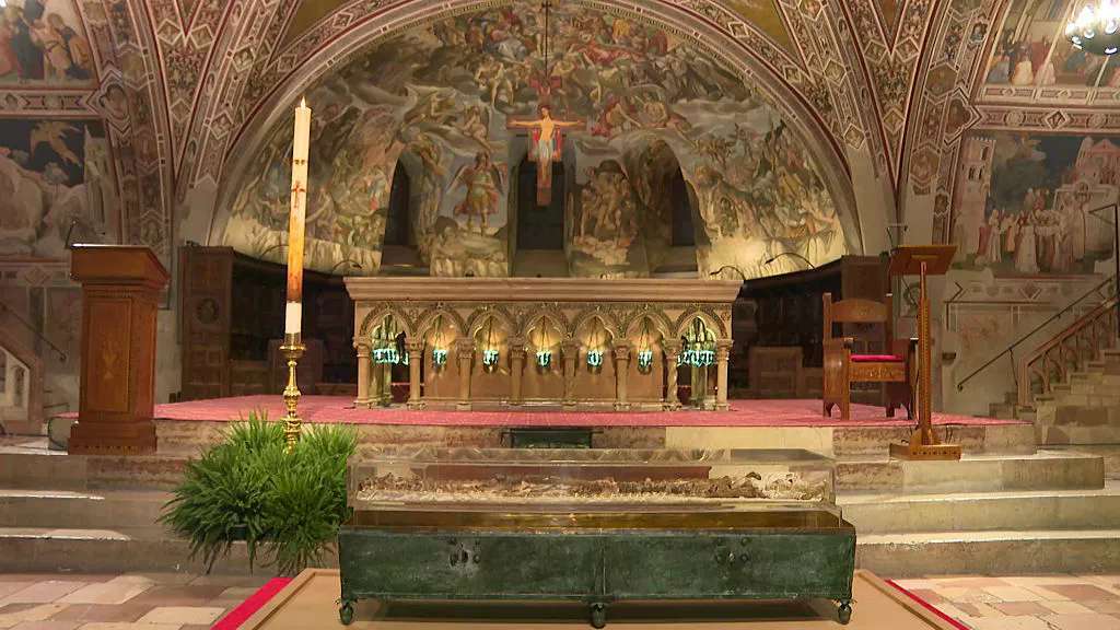 This video grab taken from an AFP shooting shows the remains of St. Francis of Assisi on display in a glass case inside the Basilica of St. Francis of Assisi during a press preview, in Assisi on February 21, 2026. (Photo by Giovanni GREZZI / AFP via Getty Images)